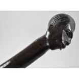 A Carved African Ebonised Barley Twist Walking Stick with Mask Head Handle