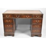 A Mid 20th century Mahogany Knee Hole Desk with Tooled Leather Top in need of restoration, Centre