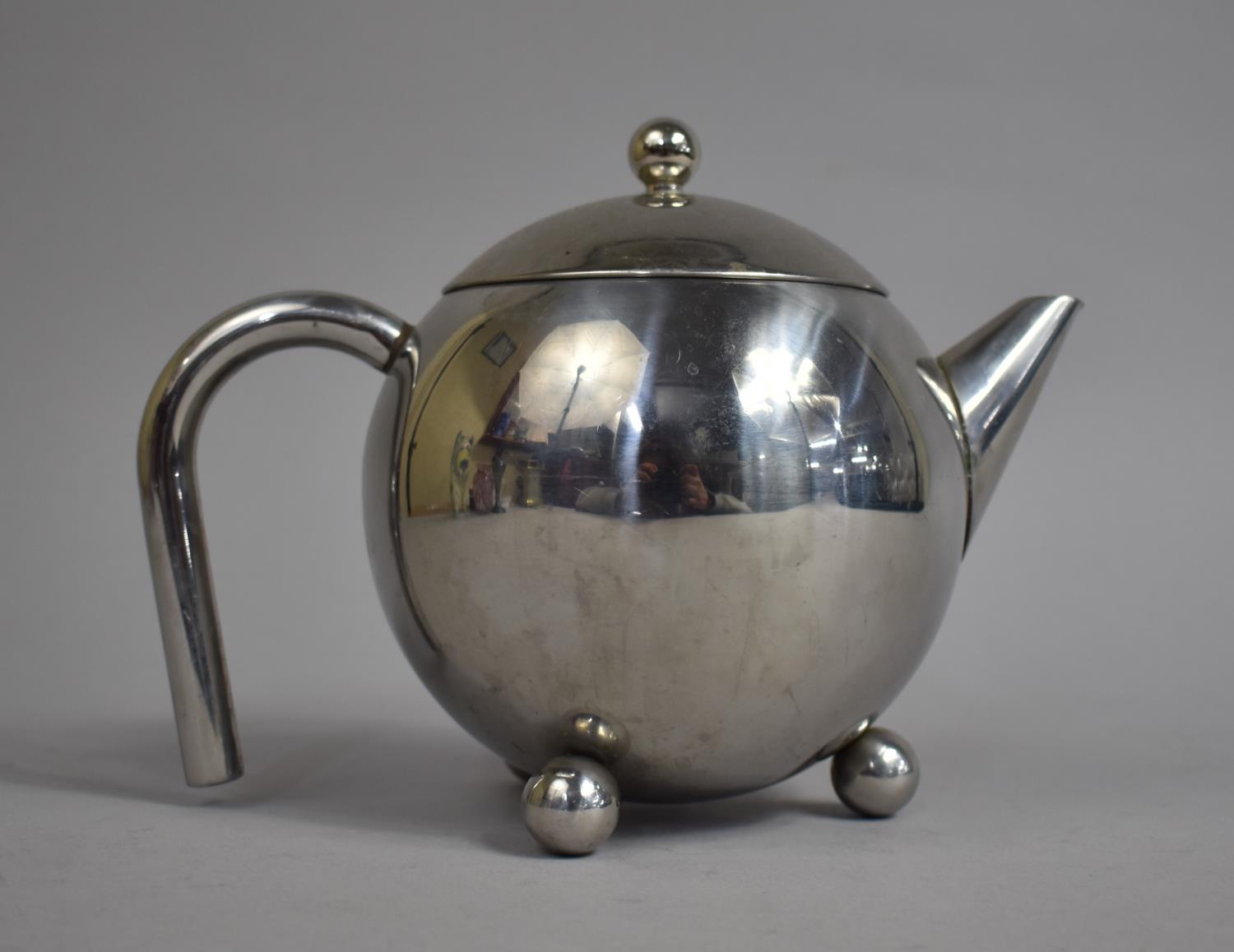 A Silver Plated Teapot with inner Strainer in the Style of Christopher Dresser on Three Ball Feet,