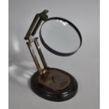 A Reproduction Desk top Magnifying Glass with Adjustable Supports in the Manner of Watts and Sons