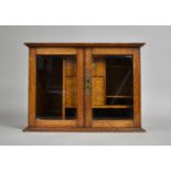 An Edwardian oak Smokers Cabinet with glazed Doors to Fitted Interior with Two Drawers, Pipe Rack