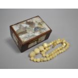 An Oriental Mother of Pearl inlaid Box containing Graduated Mother of Pearl Bead Necklace