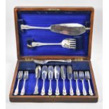 An Edwardian Oak Canteen containing Fish Knives, Forks and Servers, One Fork Replacement