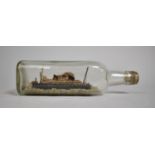 An Early 20th Century Folk Art Ship in a Bottle, Passenger Liner with Light House and Rocky Land,
