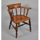 A 19th Century Elm Seated Captains Chair, with spindle back and turned legs to central stretcher