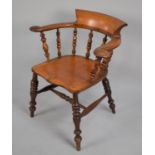 A 19th Century Elm Seated Captains Chair, with spindle back and turned legs to central stretcher