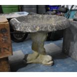 A Reconstituted Stone Bird Bath on Moulded Dolphin Tripod Support, 64cm diameter, repair to Bowl