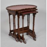 A Mid 20th Century Nest of Three Kidney Shaped Mahogany framed Tables with Tooled Leather Tops