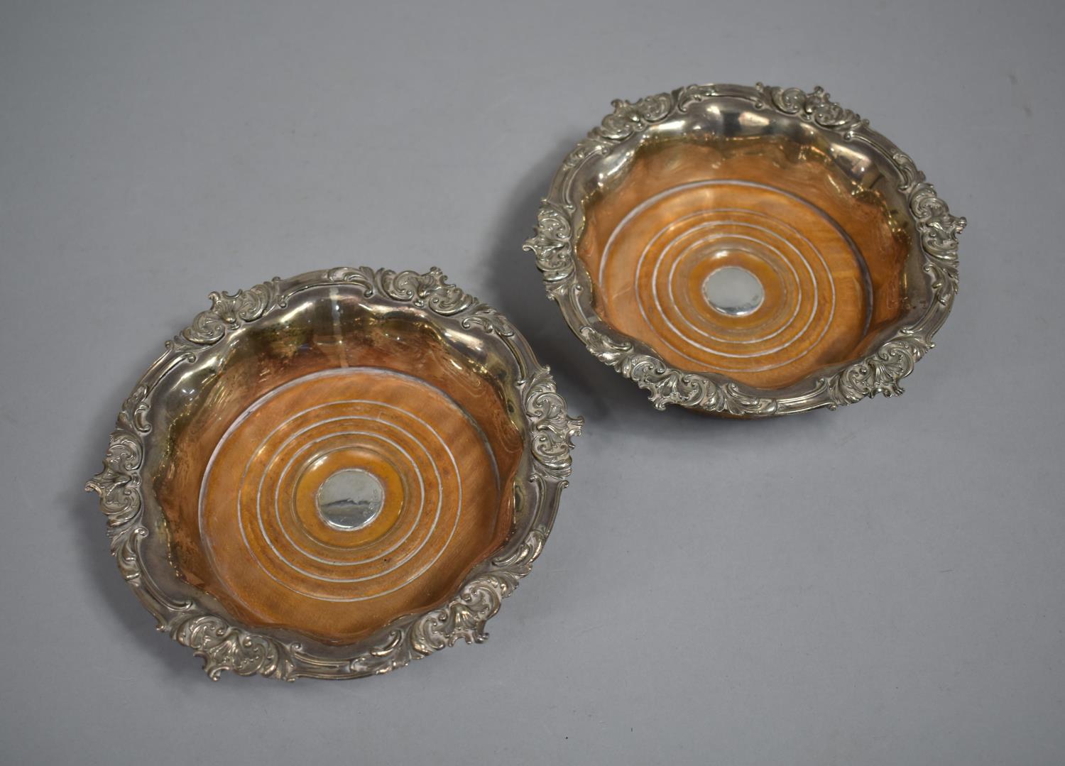 A Pair of White Metal Bottle Coasters with Relief Decorated Border and Centre Turned Section Stamped