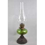 A Late Victorian Cast Iron Base Oil Lamp with Green Glass Reservoir and Plain Chimney, 46cm high