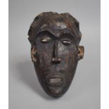 An African Carved Wooden Pan Type Tribal Mask, 25cm high