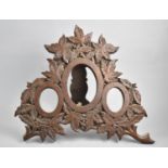 An Edwardian Carved Oak Triple Photo Frame with Easel Back decorated with Oak Leaves, 35cms Wide and