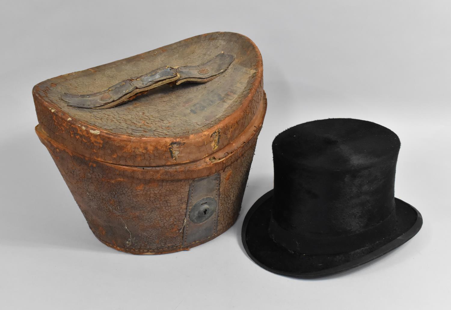 A Leather Cased Moleskin Top Hat, Case in Distressed Condition