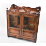 An Edwardian Oak Glazed and Galleried Smokers Cabinet, with Panelled Doors each having Inner Pipe