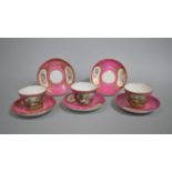 A Set of Three 18th Century Sevres Style Teacups on Pink Ground with Hand Painted Cartouches