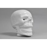 A Modern Ceramic Novelty White Glazed Money Box in the Form of a Skull, 17.5cms High