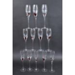 A Set of Twelve Handblown Champagne Flutes with Red Running Splat Decoration