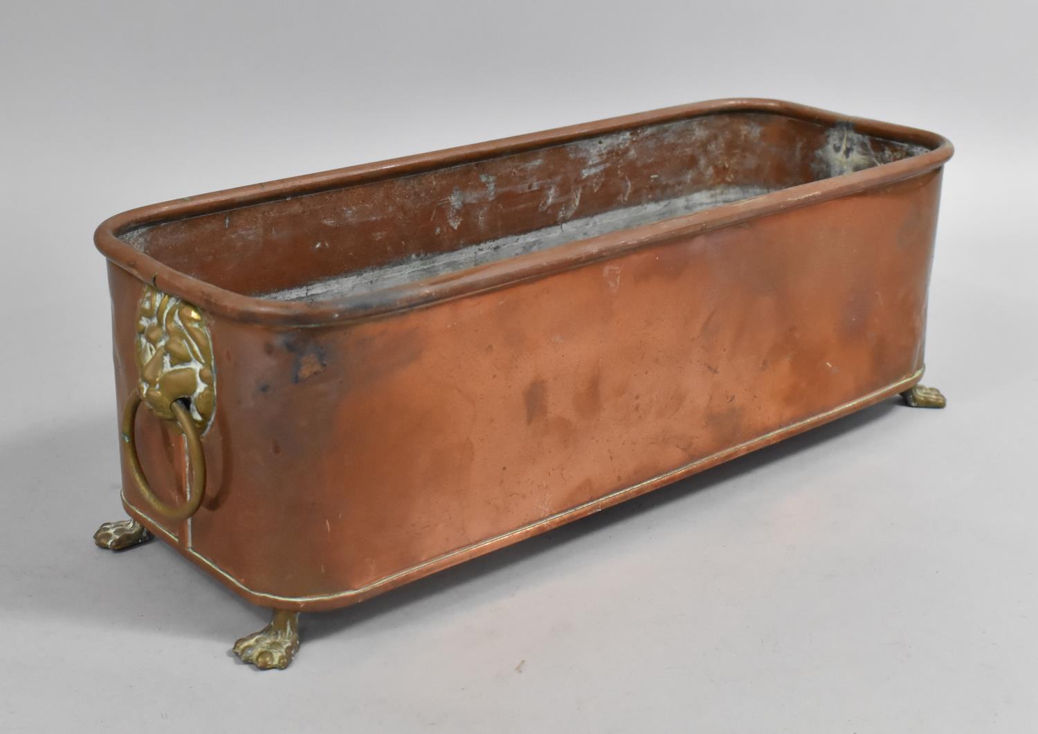 A Rectangular Copper Planter with Brass Claw Feet, Lion Mask Ring Handles, 39cms Wide