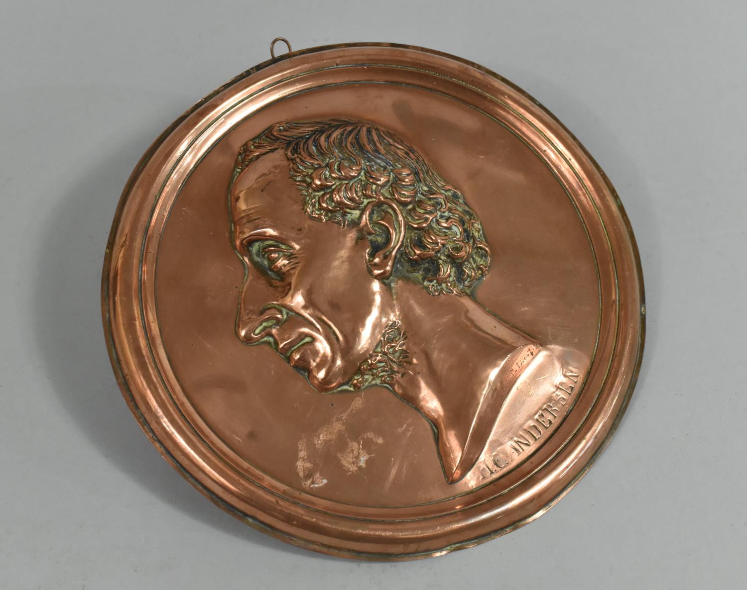 A Pressed Copper Plaque, with Bust of Hans Christian Andersen, 22cms Diameter