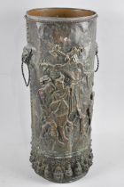 A Pressed Metal Cylindrical Stick Stand with Two Lion Mask Handles Decorated with Soldiers, 57cms
