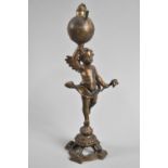 A Continental Bronzed Spelter Novelty Light in the Form of Winged Cherub Carrying Globe, 23cms High