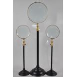 A Collection of One Large and Two Smaller Reproduction Rise and Fall magnifying Glasses, Tallest