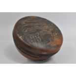 A Japanese Hardwood Circular Box with Carved Decoration t Lid depicting Buildings, Shrine and
