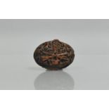 A 19th Century Carved Coquilla Nut Snuff Box decorated with Colonial Militaria Items, 7cms Long