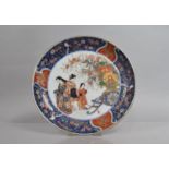 A Japanese Porcelain Charger decorated in the Imari Palette with Central Maidens Beside Cart with