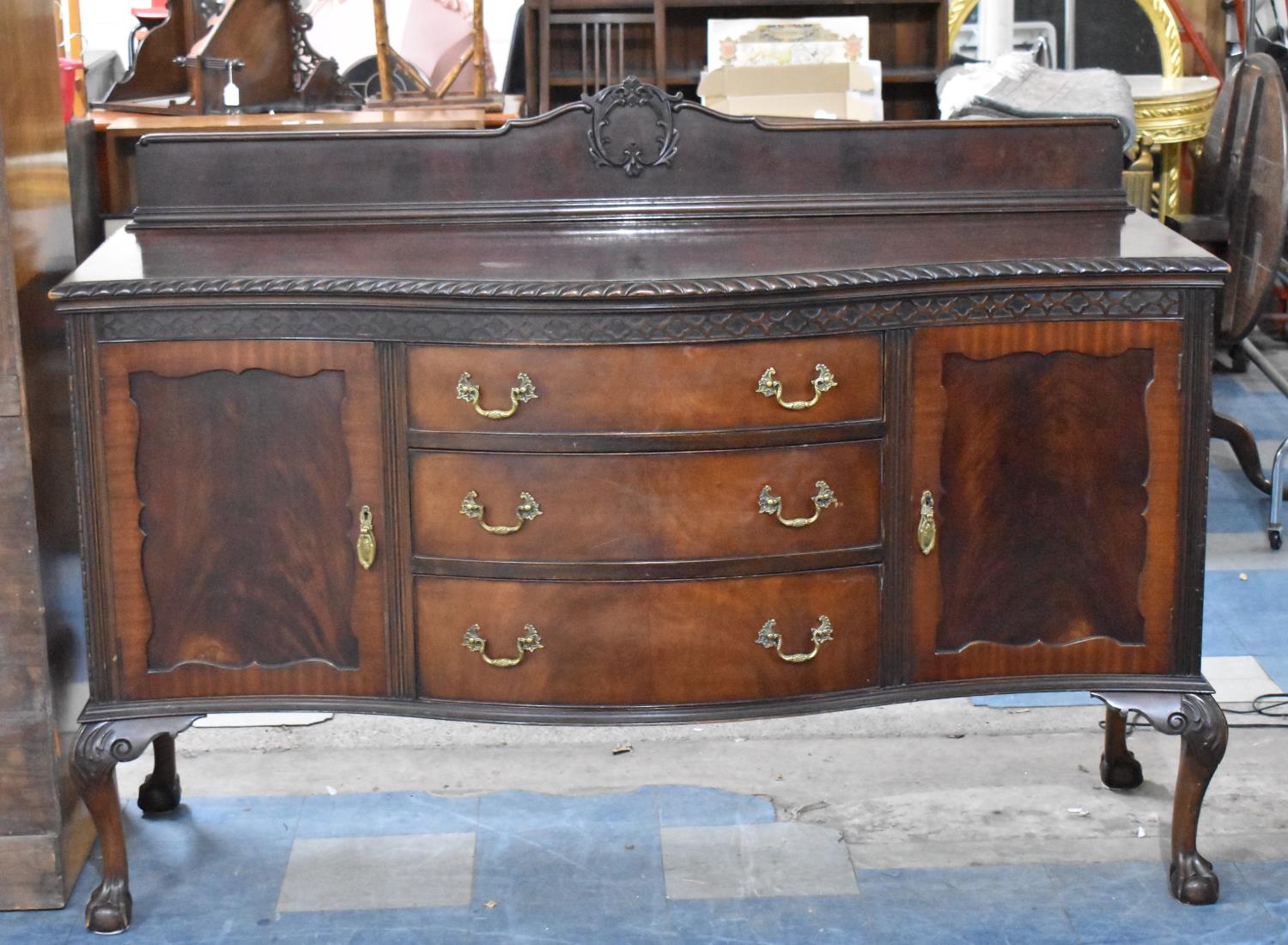 An Edwardian Serpentine Front Mahogany Sideboard with Three Centre Drawers Flanked by Two Cupboards,