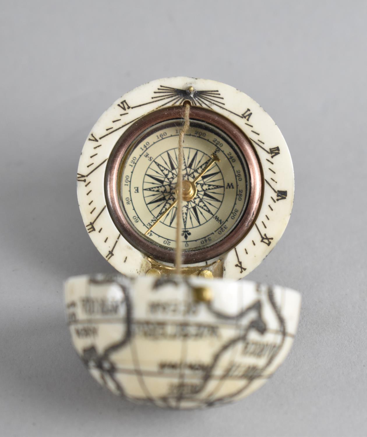 A Reproduction Scrimshaw Pocket Globe of Hinged Form with Inner Compass and Sundial, 4cms Diameter - Image 2 of 3