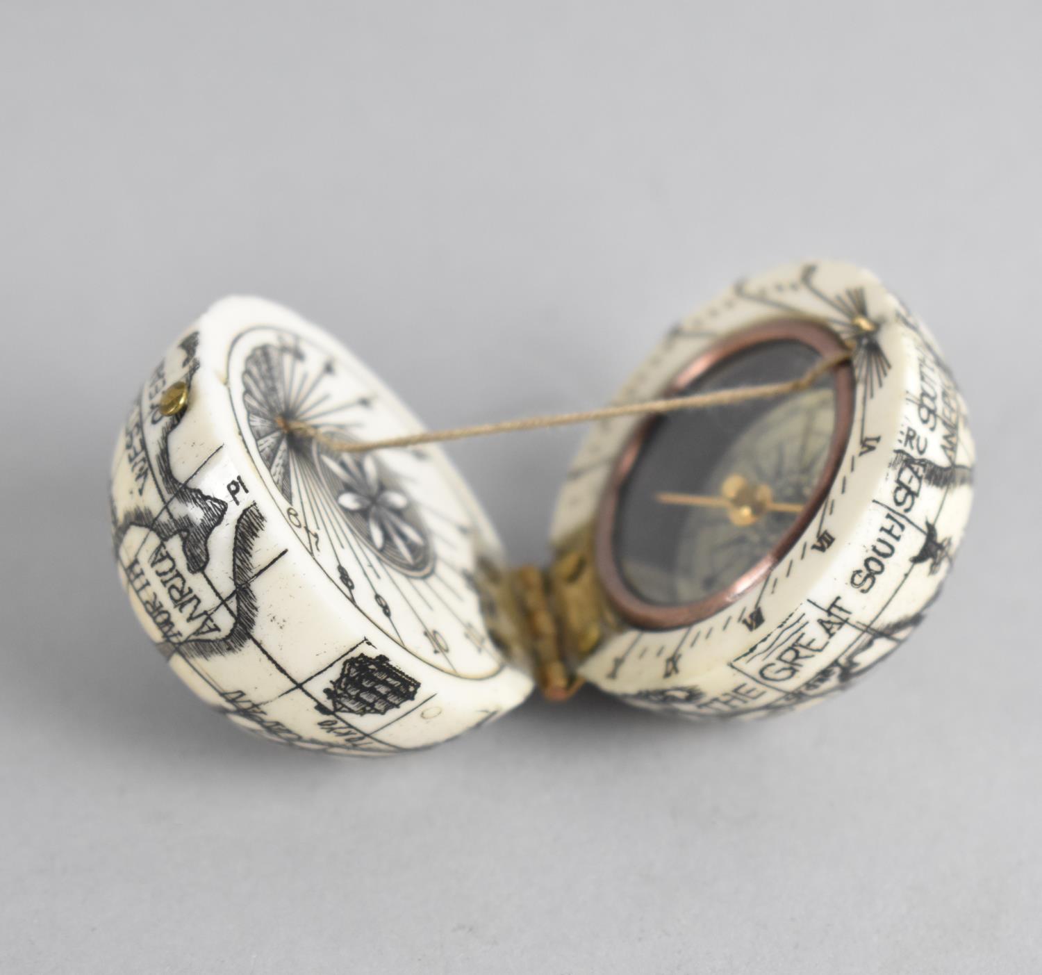 A Reproduction Scrimshaw Pocket Globe of Hinged Form with Inner Compass and Sundial, 4cms Diameter - Image 3 of 3