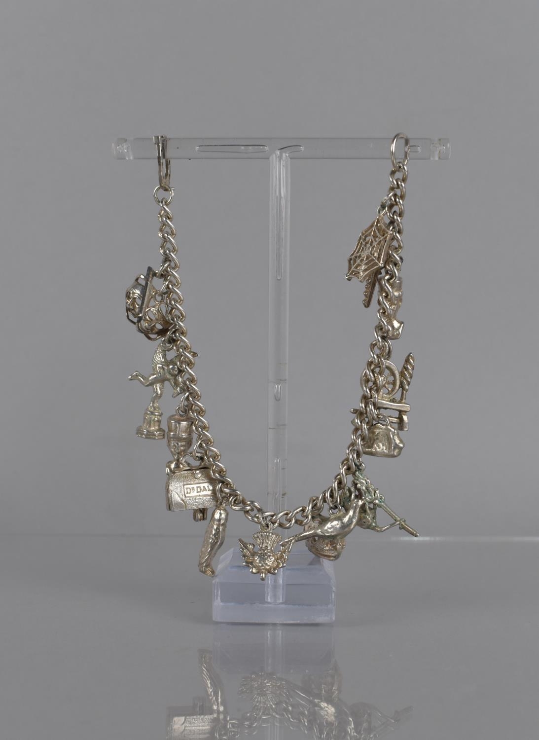 A Silver Charm Bracelet (Missing Closing Clasp) but Comprising 16 Various Silver and White Metal