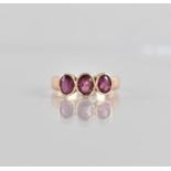 A Pretty Three Stone Rose Gold Coloured Metal (Unmarked) and Garnet Ladies Dress Ring, Centre Oval