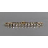 A 9ct Gold and White Sapphire Tennis Bracelet, 30 Oval Cut Sapphires Measuring 5mm by 3mm, in a Four