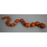 A Collection of 19th Century Orange Amber Style Beads, 60.gms, Largest Bead 28.5mm Long and Weighing