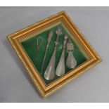 A Framed Collection of Silver Mounted and Silver Plated Shoe Horns and Button Hooks, 25.5cms Square