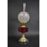 A Victorian Oil Lamp with Cranberry Glass Reservoir Supported on Brass Support complete with Frosted