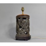 A Cast and Pierced Chinese Bronze Table Lamp on Wooden Stand with Dragon Design and Greek Key