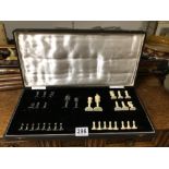 CIRCA 19TH CENTURY CASED IVORY AND BLACK STAINED IVORY CHESS SET, EACH PIECE WITH CARVED FLORAL