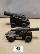 TWO SMALL VINTAGE REPLICA MODEL CANONS WITH WOODEN CARRIAGES. ‘ENGLISH NAVAL CANNON 1876 PERIOD’ AND