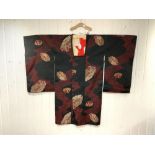 A JAPANESE RED AND BLACK DECORATED KIMONO COAT, LENGTH, 100CMS- SHOULDER 60CMS