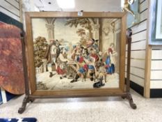 A FREE STANDING FRAMED MAHOGANY TAPESTRY OF THE 3 MUSKETEERS WITH MONK AND LADY WITH A DOG 80 X 70