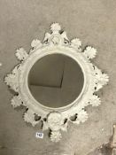 A PAINTED ORNATE METAL WALL MIRROR WITH FLORAL DECORATION MIRROR PLATE, 30CMS DIAMETER