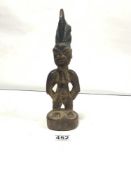 A CARVED WOOD FIGURE BY 'YORUBA SCULPTOR' OF NIGERIA OR BEVIN REPUBLIC. IT IS OF A KIND KNOWN AS '
