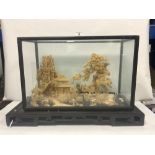 AN ORIENTAL CORK DIORAMA IN A GLAZED CASE ON A STAND, 30 X 44CMS