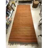 A KELIM ORNGE AND BROWN STRIPPED CARPET 310 X 166 CMS