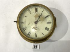 A CIRCULAR BRASS & STEEL SHIPS CLOCK WITH MILITARY CROWS FOOT CRUEDLY MARKED 18CMS DIAMETER