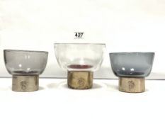 THREE STUDIO GLASS BOWLS ALL WITH SILVER WRAPPED FOOTED BASES, THE SILVER BEARING A MONOGRAM