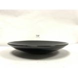 A BLACK GLAZED JAPANESE TERRACOTTA SHALLOW DISH WITH SIGNATURE TO BASE-IMOTO, 36CMS